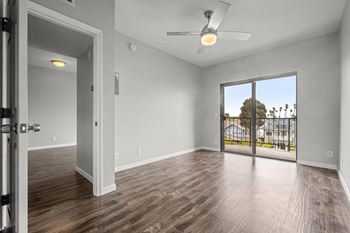 A room with a ceiling fan and sliding glass doors leading to a balcony at Lafayette Apartments, Los Angeles 90019
